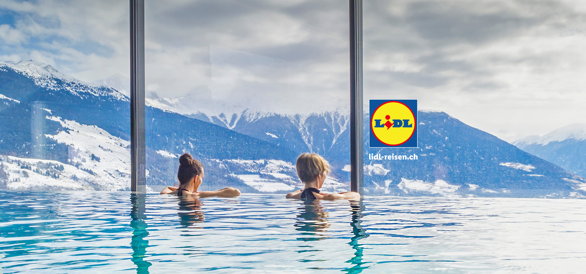 Zwei Frauen entspannen in einem Infinity-Pool mit Blick auf schneebedeckte Berge.
