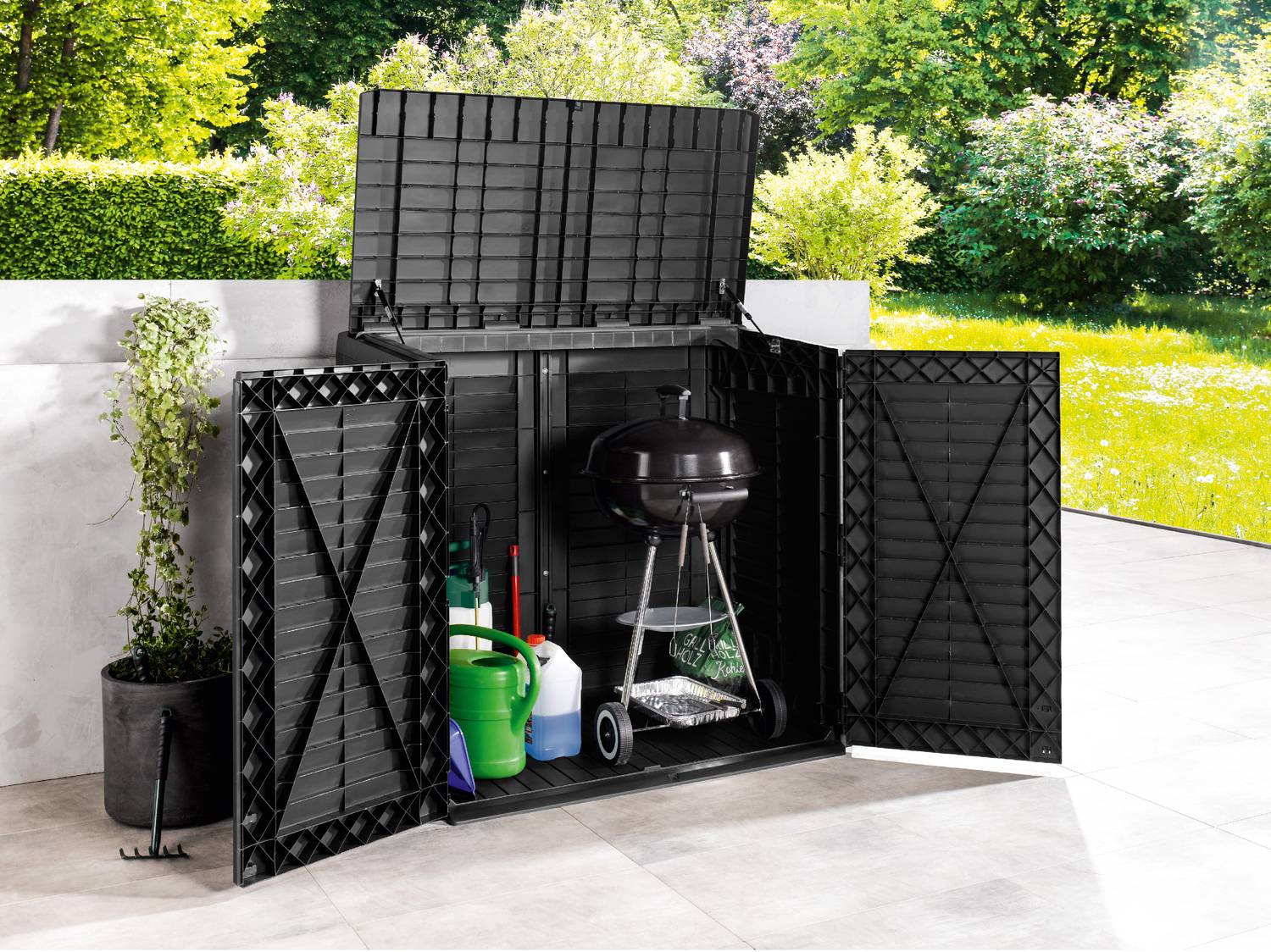 Contenitore da giardino nero con ante e coperchio aperti, contenente un barbecue e attrezzi da giardinaggio su un patio.