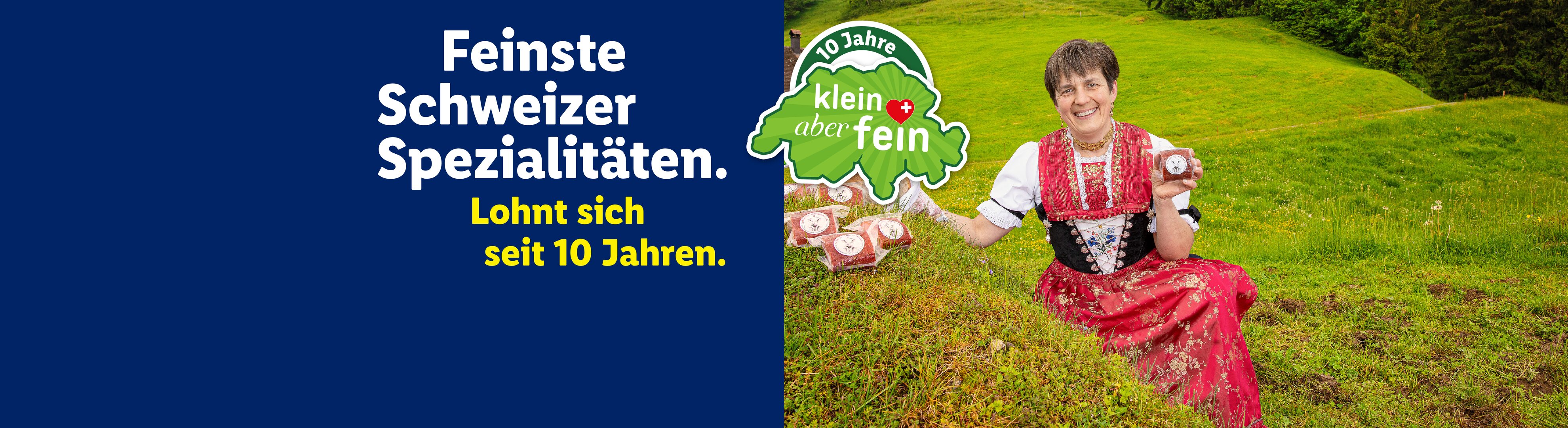 Frau in Tracht mit Schweizer Spezialitäten, beworben als „klein aber fein“ seit 10 Jahren.