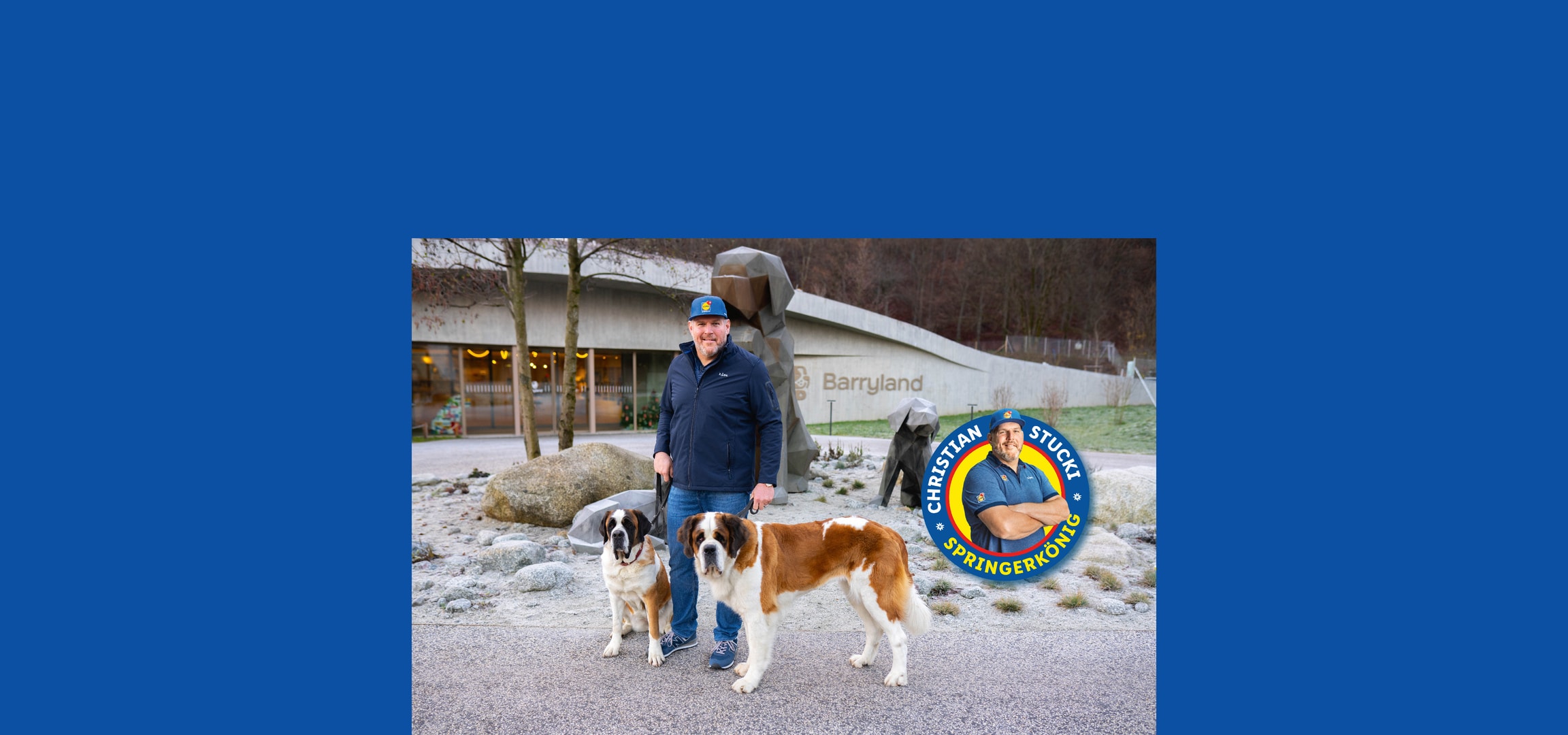 Ein Mann mit zwei Bernhardinerhunden vor dem Barryland-Gebäude.