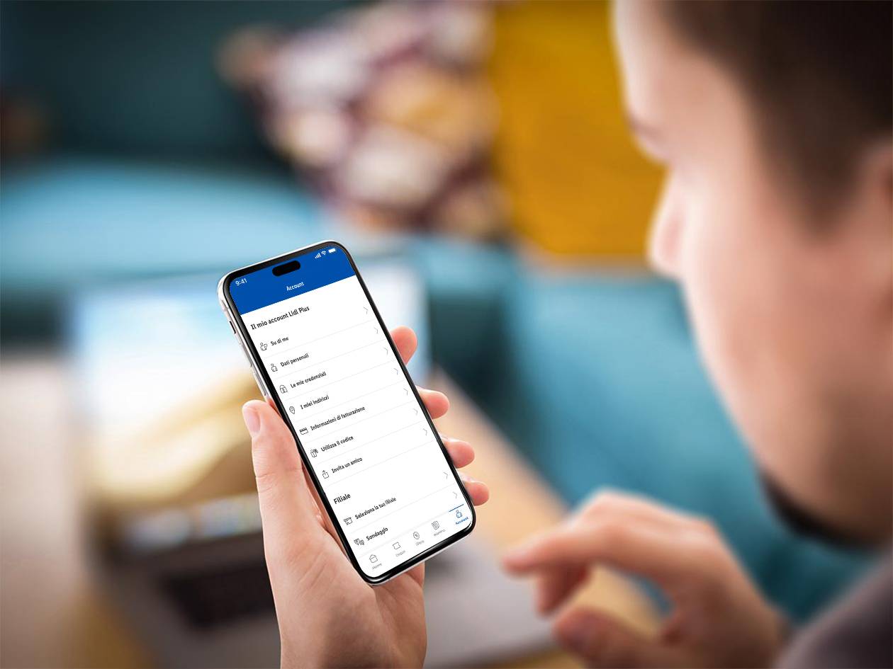 Una persona tiene uno smartphone che mostra la pagina dell'account di un'app di supermercato.